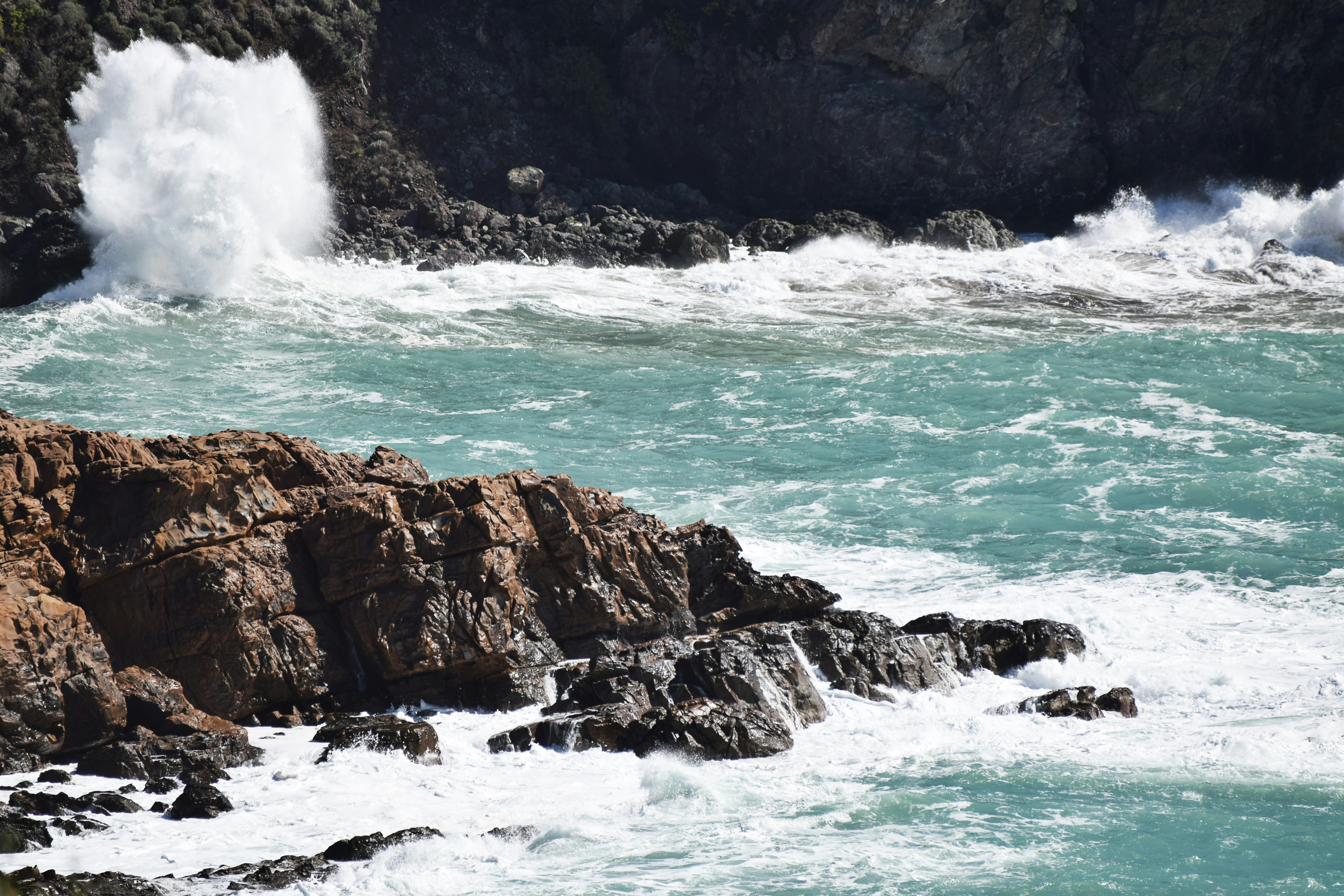 water waves hitting brown rocky shore during daytime